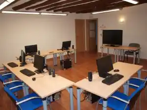 Oficina en la Fundación Campo da Roca, equipada con mesas, computadoras y sillas azules, creando un ambiente de trabajo moderno.