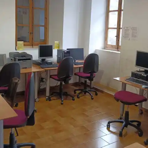 Oficina moderna con ventanas, sillas cómodas y computadoras sobre los escritorios.