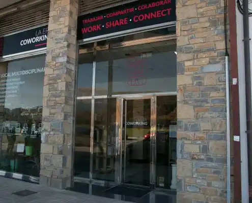 Fachada del Centro La Era Coworking con puerta de vidrio y logo visible.