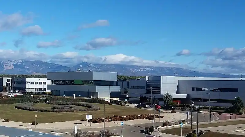 Vista exterior de los edificios de Cowalking Huesca y las montañas al fondo.