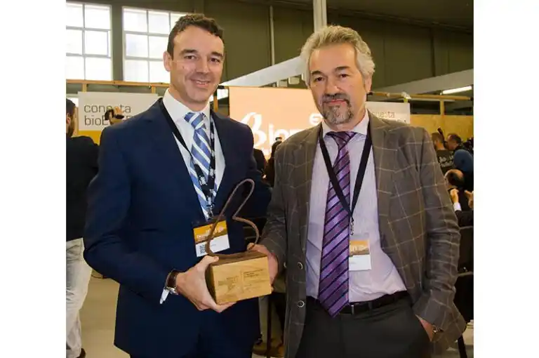 Foto de los representantes de BioCurve recibiendo un premio por su innovación en calderas de biomasa.